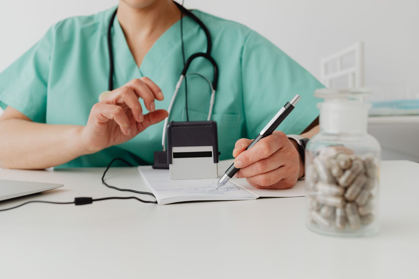 Une main remplit une feuille de soins au stylo sur un bureau